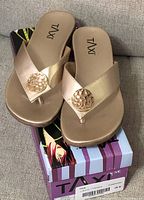 Front view of the new gold thong sandals on top of original Taxi box.