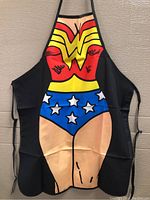 Full view of Wonder Woman apron laid against wall showing superhero costume print
