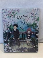 Front cover of sealed DVD showing two main characters standing under cherry blossoms
