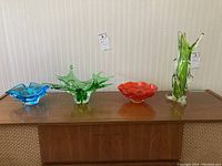 Four art glass pieces on wooden surface
