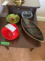 Four items including three ashtrays and one dish on wooden table