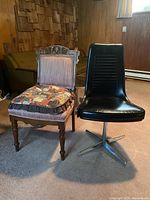 Both chairs side by side on carpeted floor showing the wooden dining chair with cushion and black vinyl swivel chair