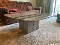 Full side view of polished grey granite coffee table showing square top and cube base