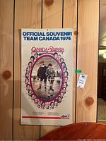 Full view of the vintage Official Souvenir Team Canada 1974 hockey poster showing Canada-Russia series artwork on a wooden background.