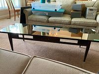 Wide angle view of the coffee table with mirrored glass top reflecting the room and furniture.