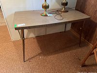 Full view of the Mid Century Modern table showing the metal legs and wood grain surface with leaf inserted.