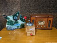 Photo showing the ceramic duck lamp on left, manual coffee grinder in middle, and Electrohome vintage style wooden radio on right.