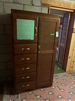 Full view of the dark brown wood wardrobe showing the mirror, drawers, and doors.