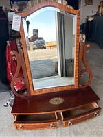 Front view of antique mahogany vanity mirror with drawers and arched top mirror.