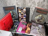 Photo showing nine gardening and design books arranged in two rows leaning against a wall, including duplicates of The Chinese Garden, a red book titled A History of Western Art, and several notebooks featuring floral covers.