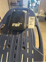 Close-up of the black padded headrest showing the 'Teeter Hang Ups' branding and a tag indicating the item is an inversion table by Teeter.