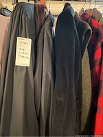 First image showing several dark jackets including velvet tuxedo and synthetic suit jackets hung on a bar with a MaxSold tag.