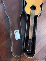 Full view of the guitar inside the hard case with McSold tag visible for scale.