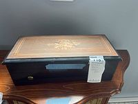 Exterior view of closed wooden box showing inlaid motif on lid