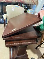 Photo showing the tabletop partially lifted to display the spinning top mechanism underneath.