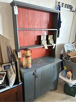 Full view of the vintage wooden shelf with upper shelves and lower cabinet, showing the blue/green and red-orange colors and overall condition.