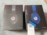Two boxes of Beats Studio 2 wireless headphones, black and blue models, closed in original packaging