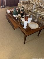 Front view of wooden coffee table with decorative items on top in living room.