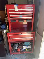 Full view of red Craftsman tool chest with multiple drawers and visible contents in bottom drawer.