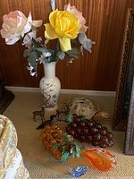 Full view of the lot showing floral vase with artificial flowers, glass grapes, brass figurines, and ceramic turtle