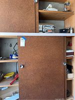 Wooden shelves with several small hand tools and accessories.
