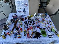 Overview of entire collection including figures, toys, and game pieces on a white cloth with Toronto Blue Jays bag in background.