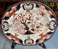 Full front view of oval platter on stand showing overall Imari pattern