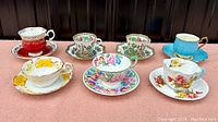 Top view of seven vintage bone china teacups with saucers, showing various colorful floral and decorative patterns