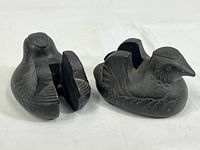 Front and top angle view of the pair of cast iron duck-shaped weights showing detailed feather etching and vertical slots.