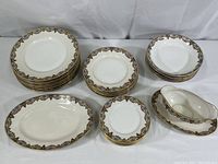 Full set of plates, bowls, serving platter and gravy boat shown on table.