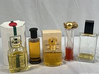 Five perfume bottles including a boxed Armani bottle and various other brands, some partially used.
