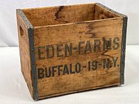 Front side of the wooden milk crate showing the brand name 'Eden Farms' and location 'Buffalo, N.Y.' with metal reinforcing straps on edges.