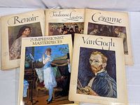 Five portfolios and a soft cover book displayed. Covers show famous impressionist artists' works: Renoir, Toulouse-Lautrec, Cezanne, Van Gogh, and the Impressionist Masterpieces book.