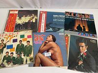 Top view showing six vinyl records with album covers, various artists and themes with Japanese text and imagery