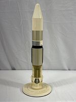 Full view of vertical missile model on circular display base with measurement markings, showing all color details and structure.