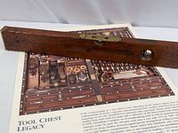 Photo showing the vintage Stanley wood level laid on top of the Taunton Press woodworking tool poster.