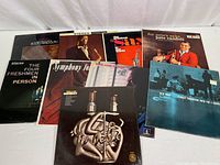 Wide view of nine vintage jazz vinyl albums showing all album covers clearly on white surface.