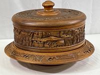 Front angle of the complete set with plate cover on base, showing carved relief details and knob handle.
