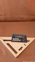 Photo showing the new Mastercraft 7-inch aluminum rafter square in original packaging placed on a brown surface