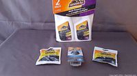 Five Armor All branded auto cleaning products: four packs of Original Protectant wipes and one Tire Foam cleaner in sealed packaging.
