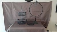 Full view of largest piece (two-tier basket stand), round basket, and decorative frame
