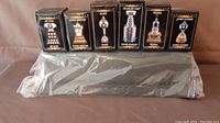 New sealed McDonalds mini hockey trophy set boxes and silver plastic display stand arranged on a surface.