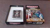 Photo of Monopoly Prizm NBA Trading Cards Set 5 box open showing trading cards in protective case inside.
