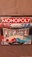 Front of Monopoly Prizm NBA board game box showing game branding and player cards illustration.