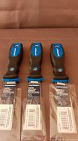 Photo showing three new Mastercraft putty knives with identifying tags on each blade.