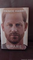 Hardcover book 'Spare' by Prince Harry with cover showing a close-up portrait of Prince Harry.