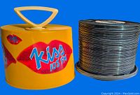 Yellow record caddy with KISS 108 FM logo and stack of vinyl records on the side