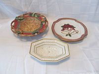 Set of three bowls: autumn-themed with handles, Christmas-themed with bells, and small white octagonal bowl