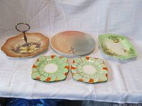 Overview showing all dishes together on white backdrop: 4 bread and butter plates, handled serving dish, rectangular serving dish, dinner plate