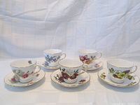 Five Ridgway Royal Vale teacup and saucer sets each with different floral patterns, displayed in a group.
